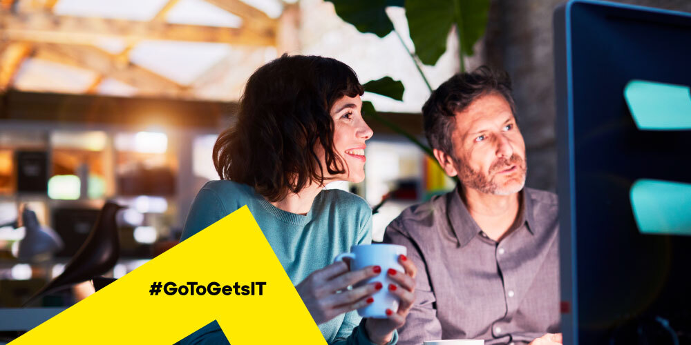 Two colleagues looking at a computer monitor together evaluating remote support software