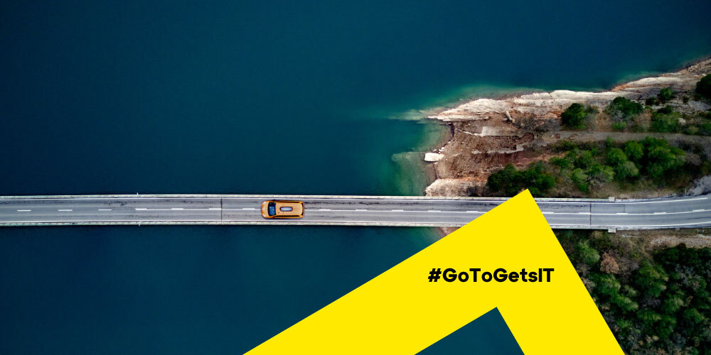 Bovenaanzicht van een auto op een brug als metafoor voor het onderhouden van IT-infrastructuur met een checklist voor patchbeheer.