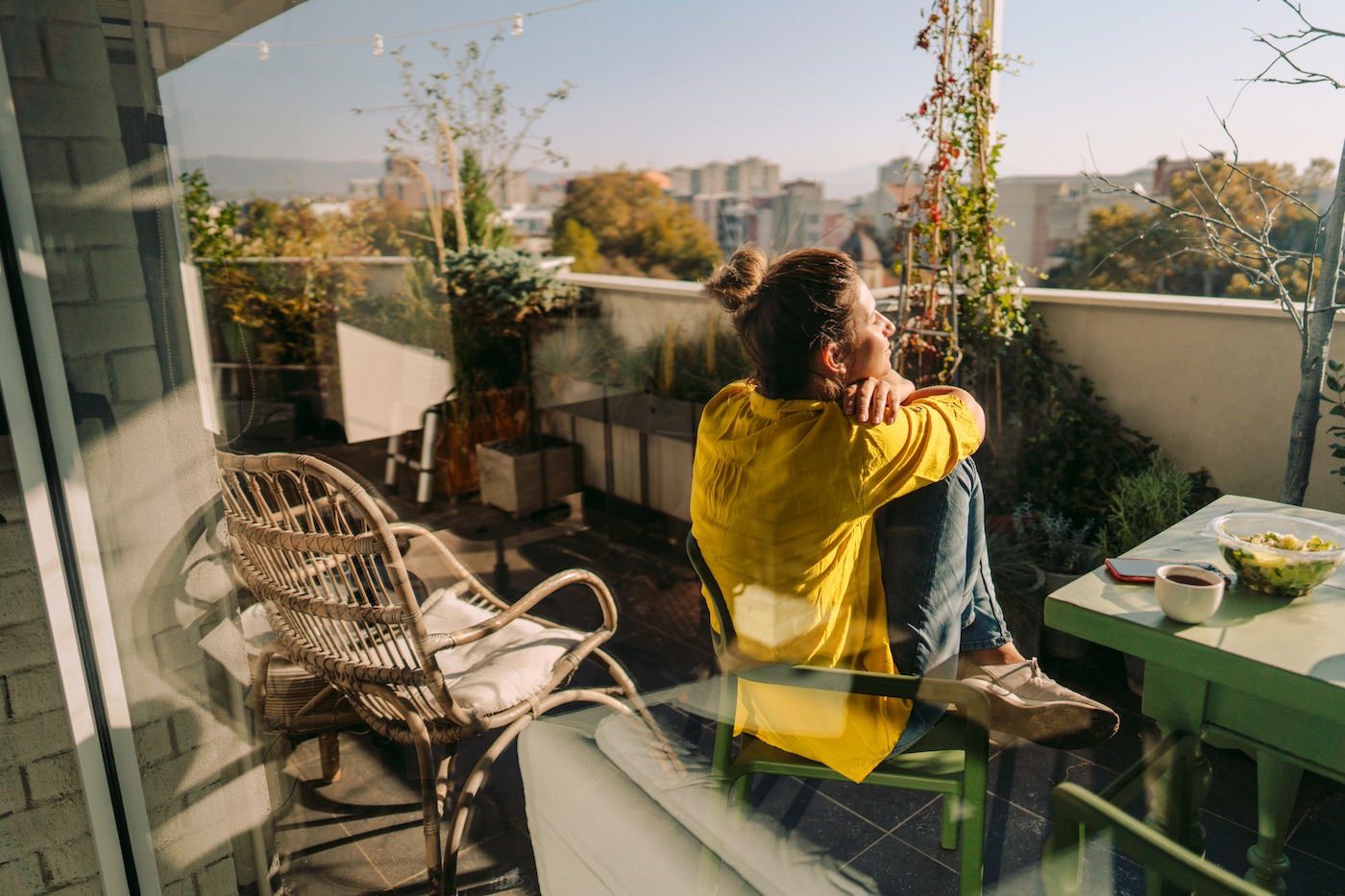 Individual sitting outside home on patio enjoying the sun.