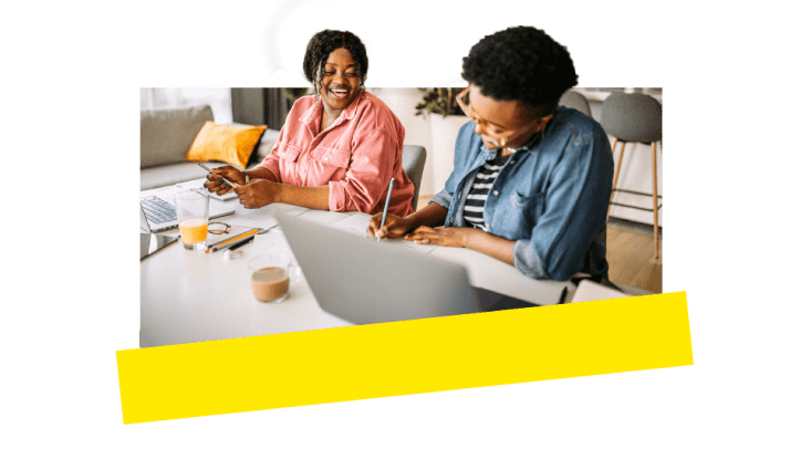 Due colleghi ridono e si divertono mentre lavorano insieme grazie agli strumenti VoIP.