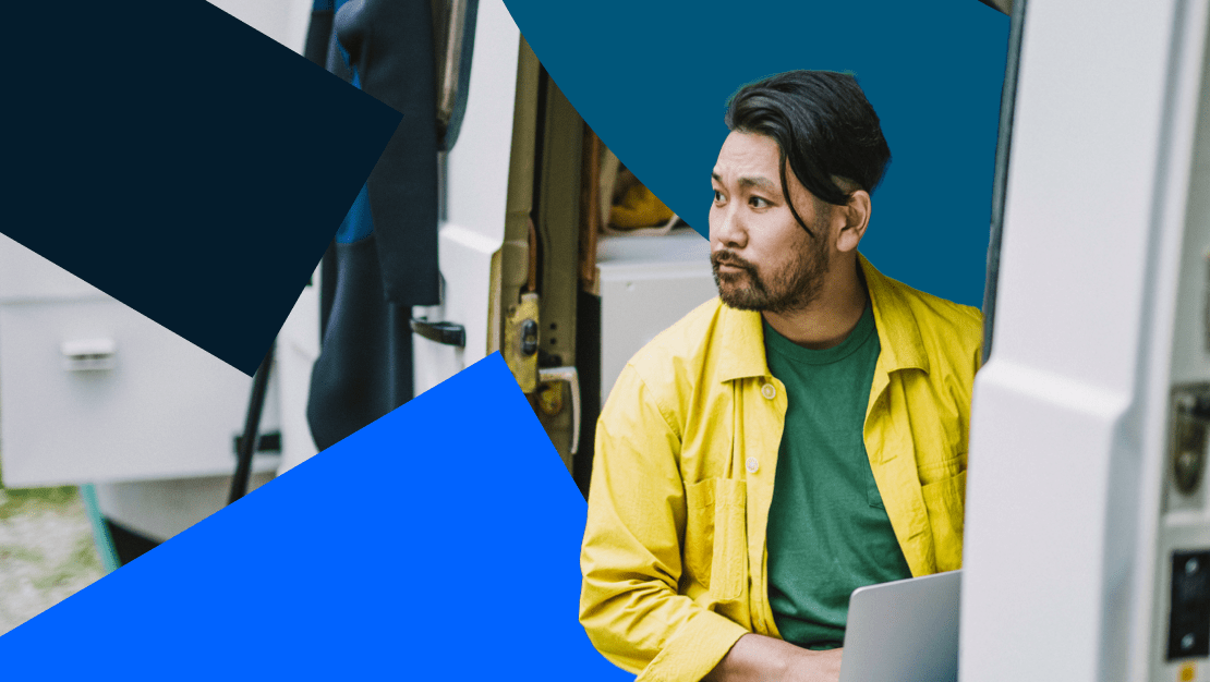 Dipendente a distanza con una camicia gialla che lavora dal suo furgone durante un viaggio.