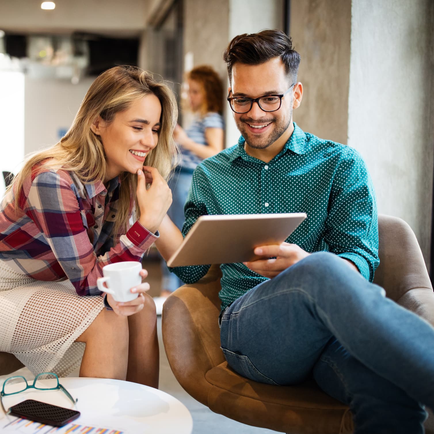 Alcuni colleghi in ufficio che lavorano su un tablet in tutta sicurezza grazie alla soluzione di gestione dei dispositivi mobili di GoTo Resolve.
